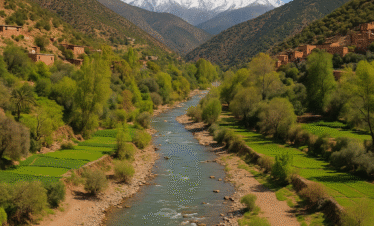 Valle de Ourika en Marruecos con río, vegetación verde y montañas del Atlas cubiertas de nieve al fondo
