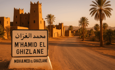 Entrada al pueblo de M’Hamid El Ghizlane en Marruecos con palmeras y kasbahs de adobe al atardecer
